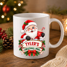 Personalised Santa Christmas mug in glossy white ceramic with a name on a wooden sign