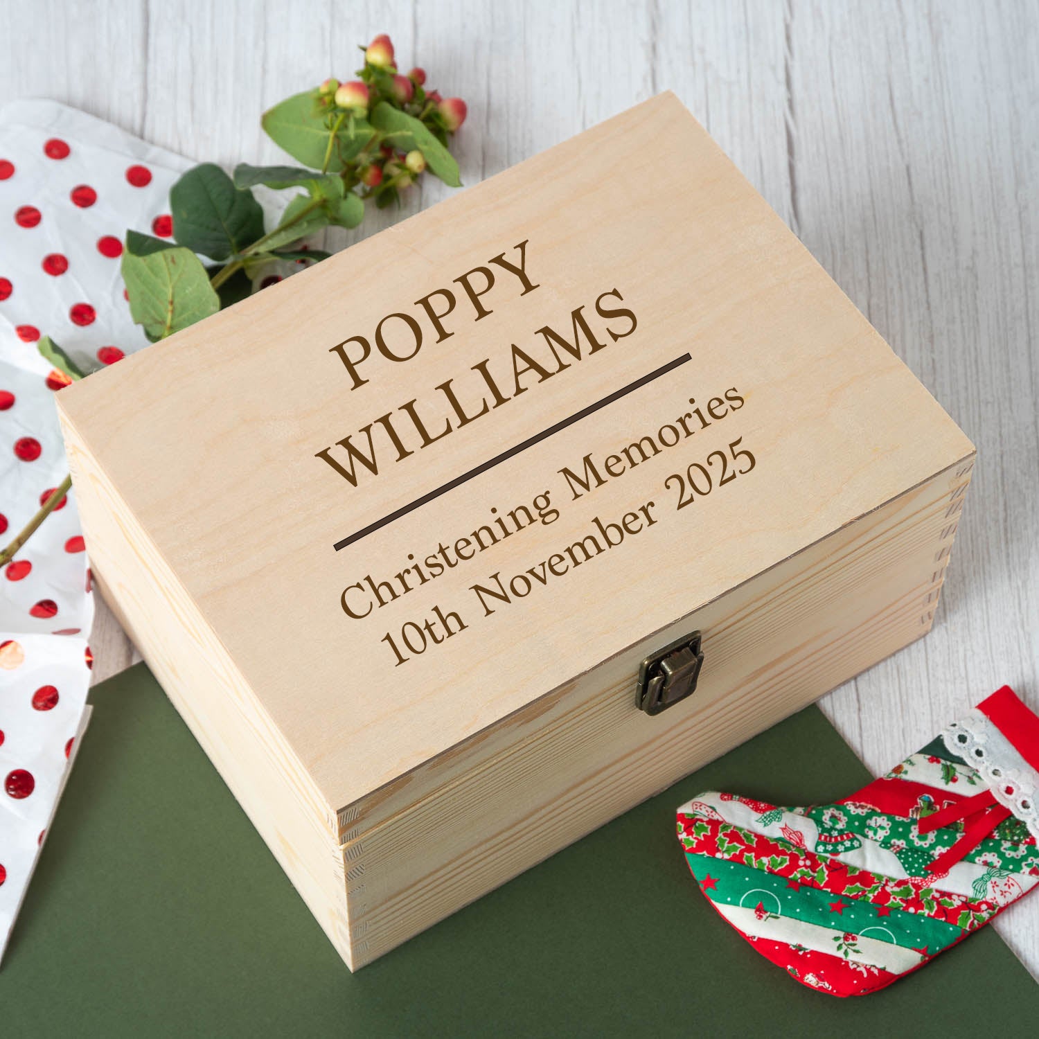 Wooden box engraved with 'Poppy Williams' and 'Christening Memories 10th November 2025' on a wooden surface.